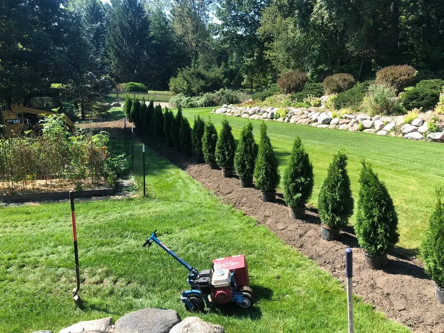 A lawn mower is parked in the middle of a garden.